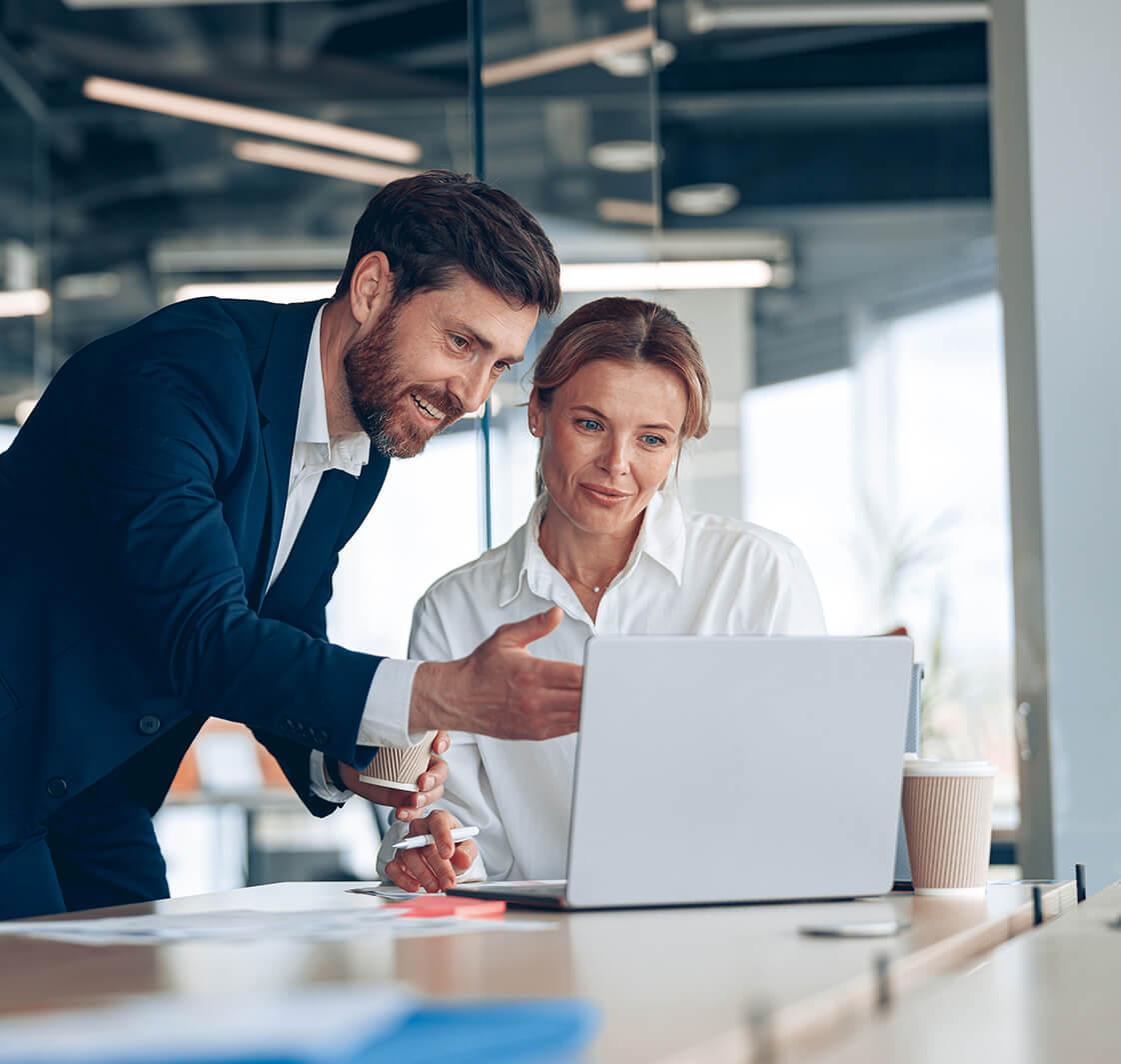 Female boss discussing online project with employee showing presentation to experienced team leader.