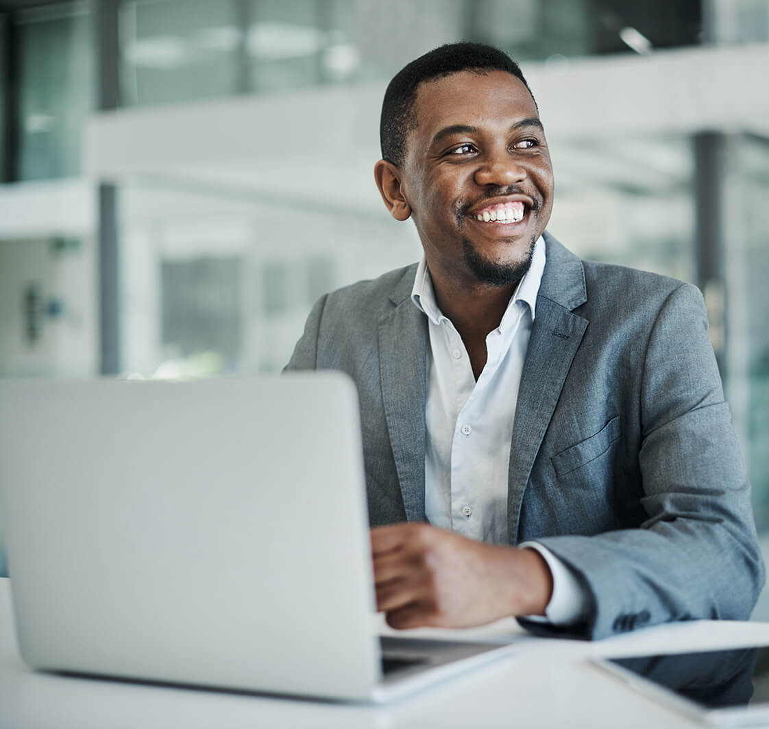 Shot of a young businessman sitting alone in his office and using his laptop.