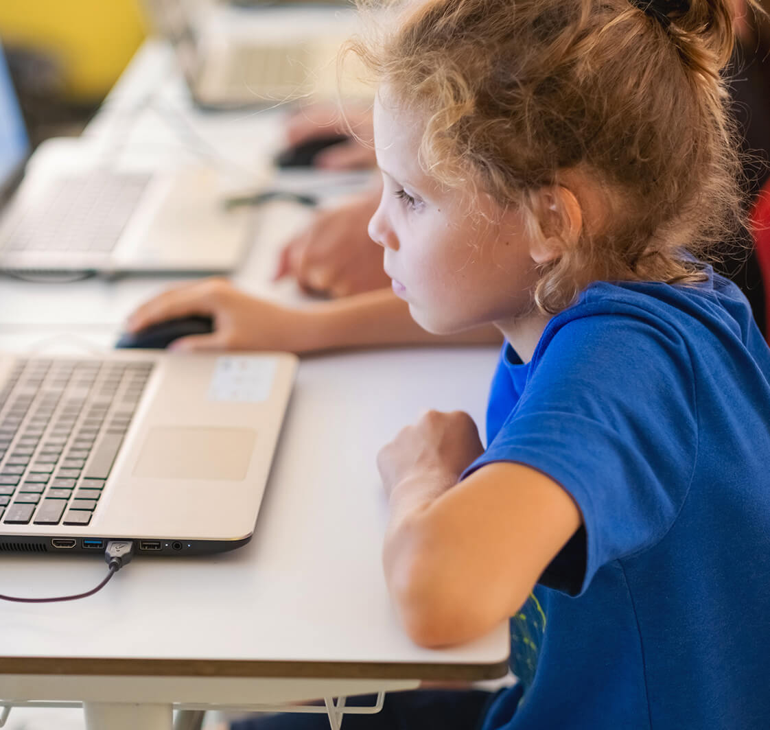 Students working at laptop computers in a classroom of primary school.