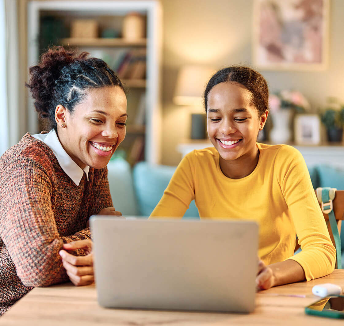 Mother and daughter home learning on a laptop.