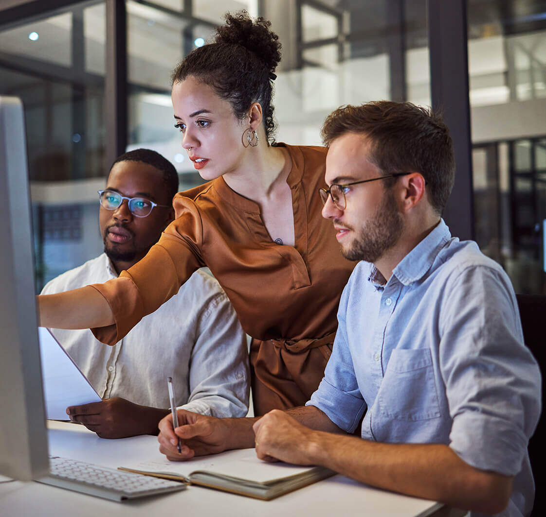 Three people looking at a computer screen.