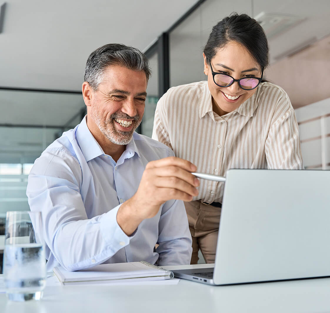 Two happy diverse professional executives team working in office using pc laptop.