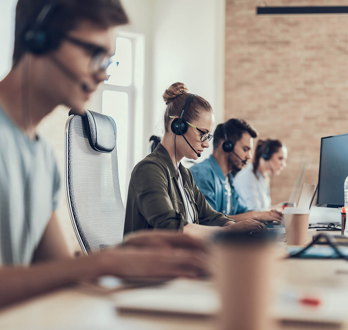 Young woman in glasses is sitting in the call centre.