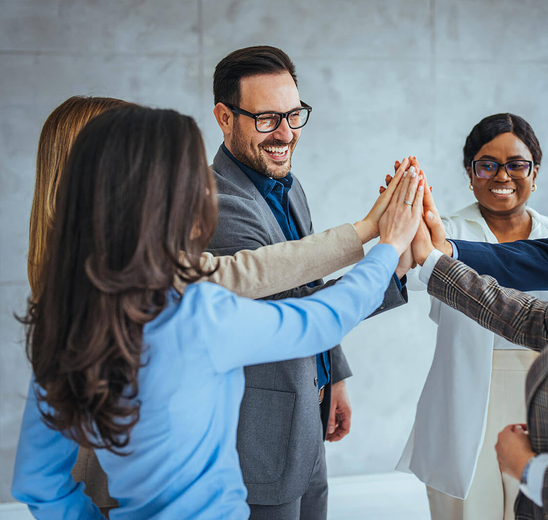 Team Celebrating Success With High Five in Office.