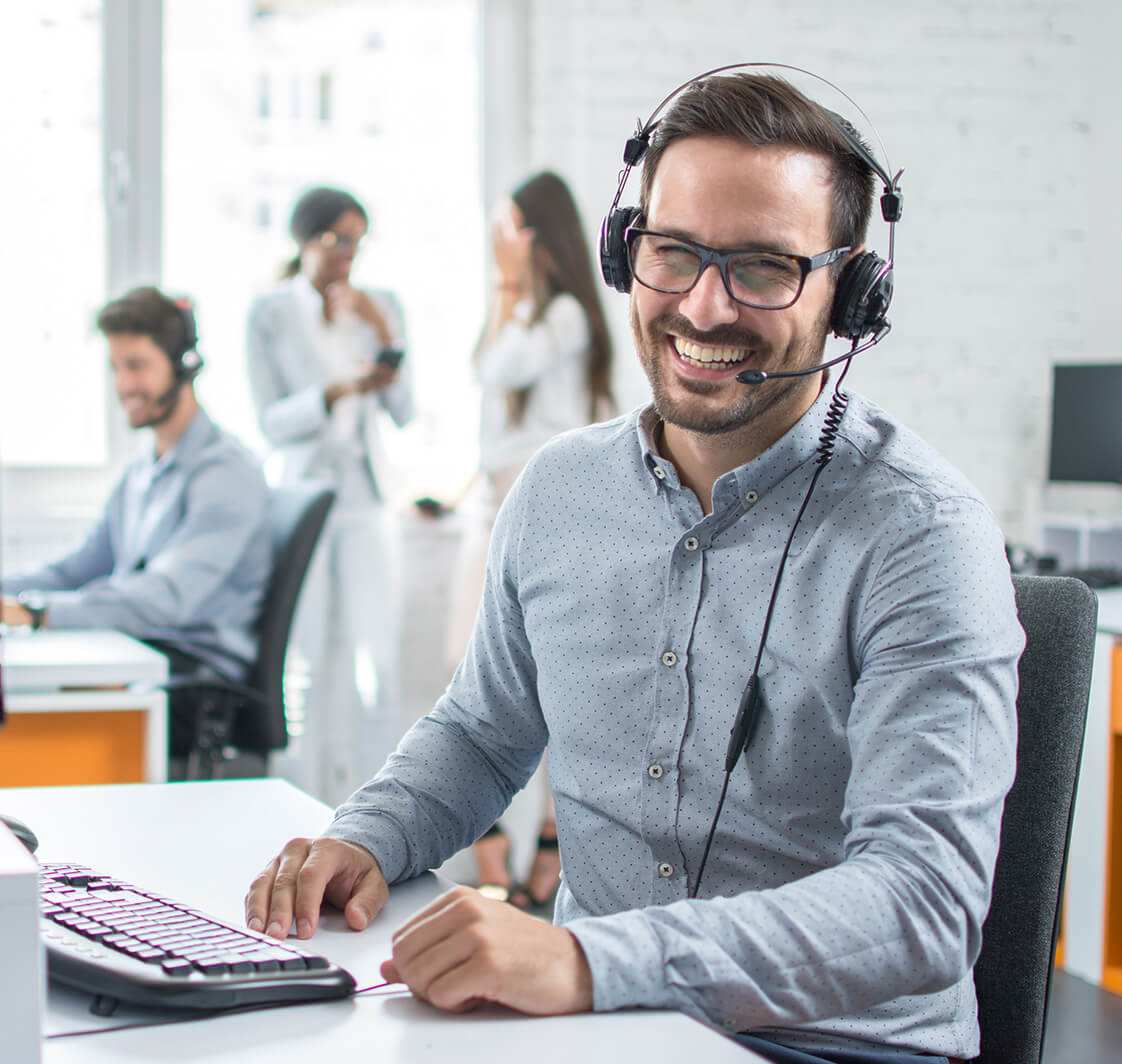 Happy young male customer support executive working in office.