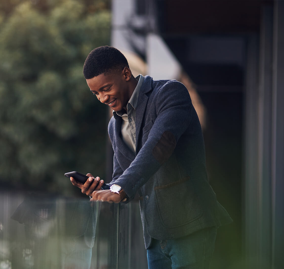 Man on a balcony having a conversation on his phone.