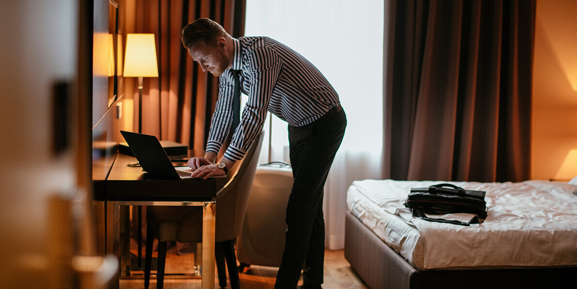 Man in a hotel room using a laptop.