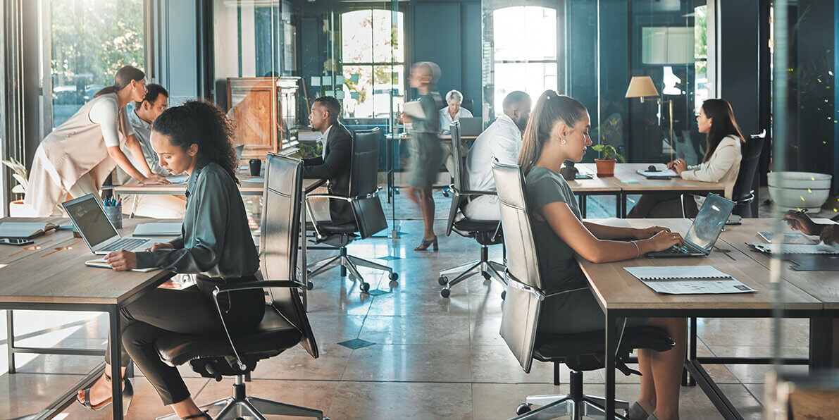 Busy office space with people working at desks.